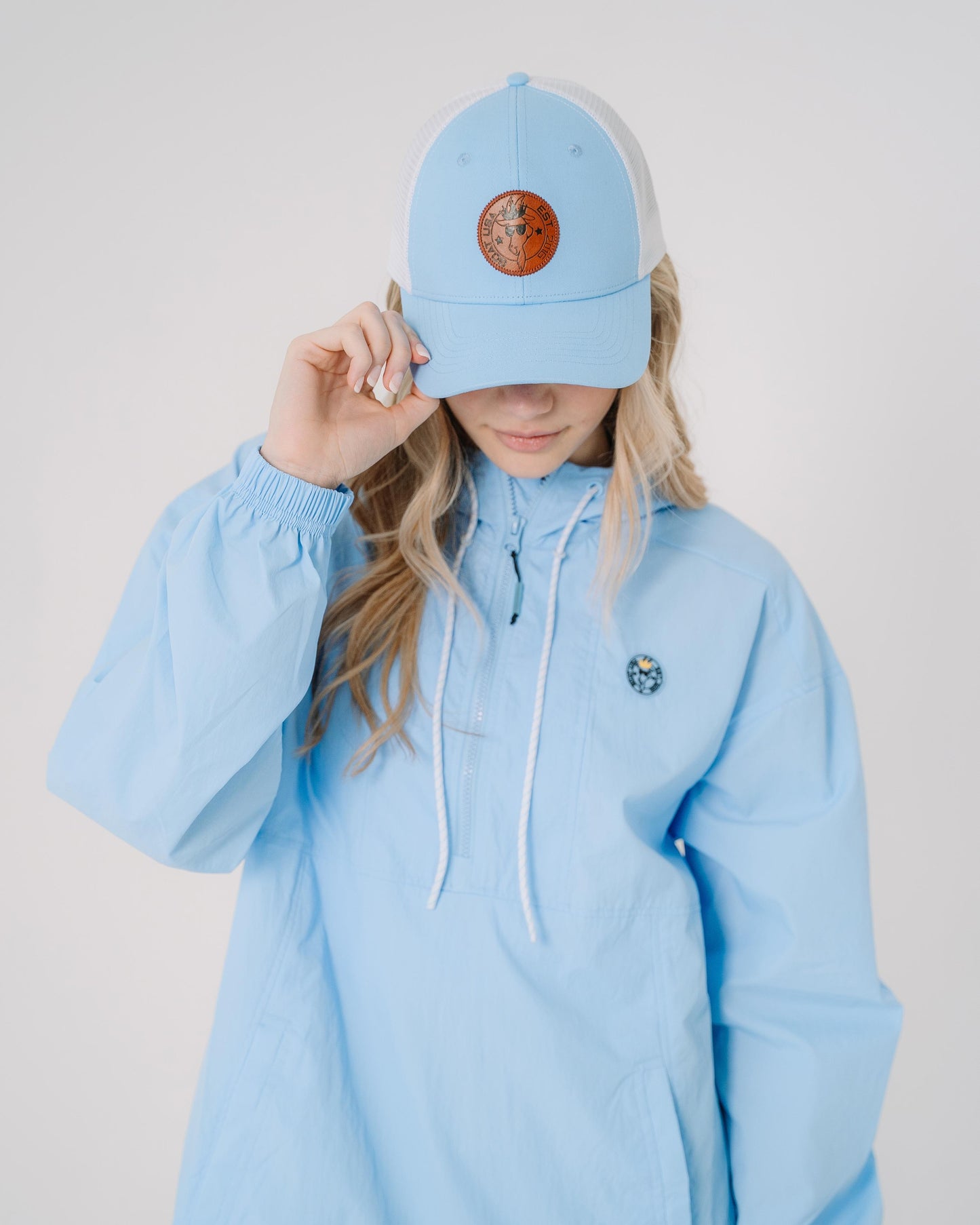 Girl wearing carolina blue hat with white mesh and brown leather patch#color_carolina-blue