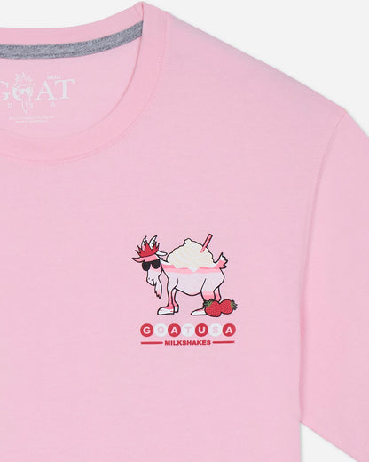 Pink t-shirt with a cartoon goat design and branding on a light gray background.
