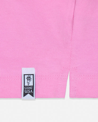 Close-up of a pink garment with a visible label on a white background