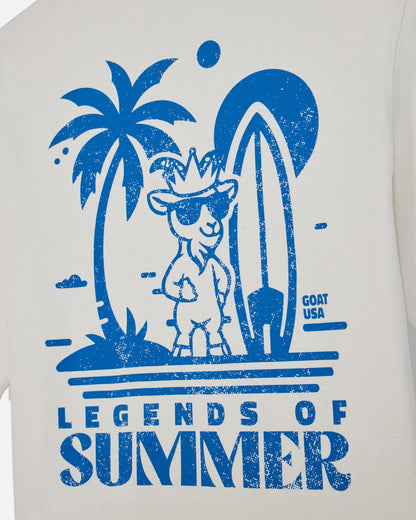 T-shirt with blue graphic of a goat with sunglasses, palm tree, and surfboard with 'Legends of Summer' text on a white background.