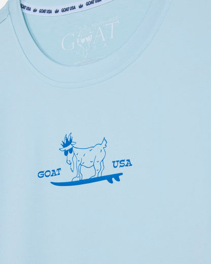 Light blue t-shirt with a graphic of a goat on a surfboard and 'GOAT USA' text.#color_delicate-blue