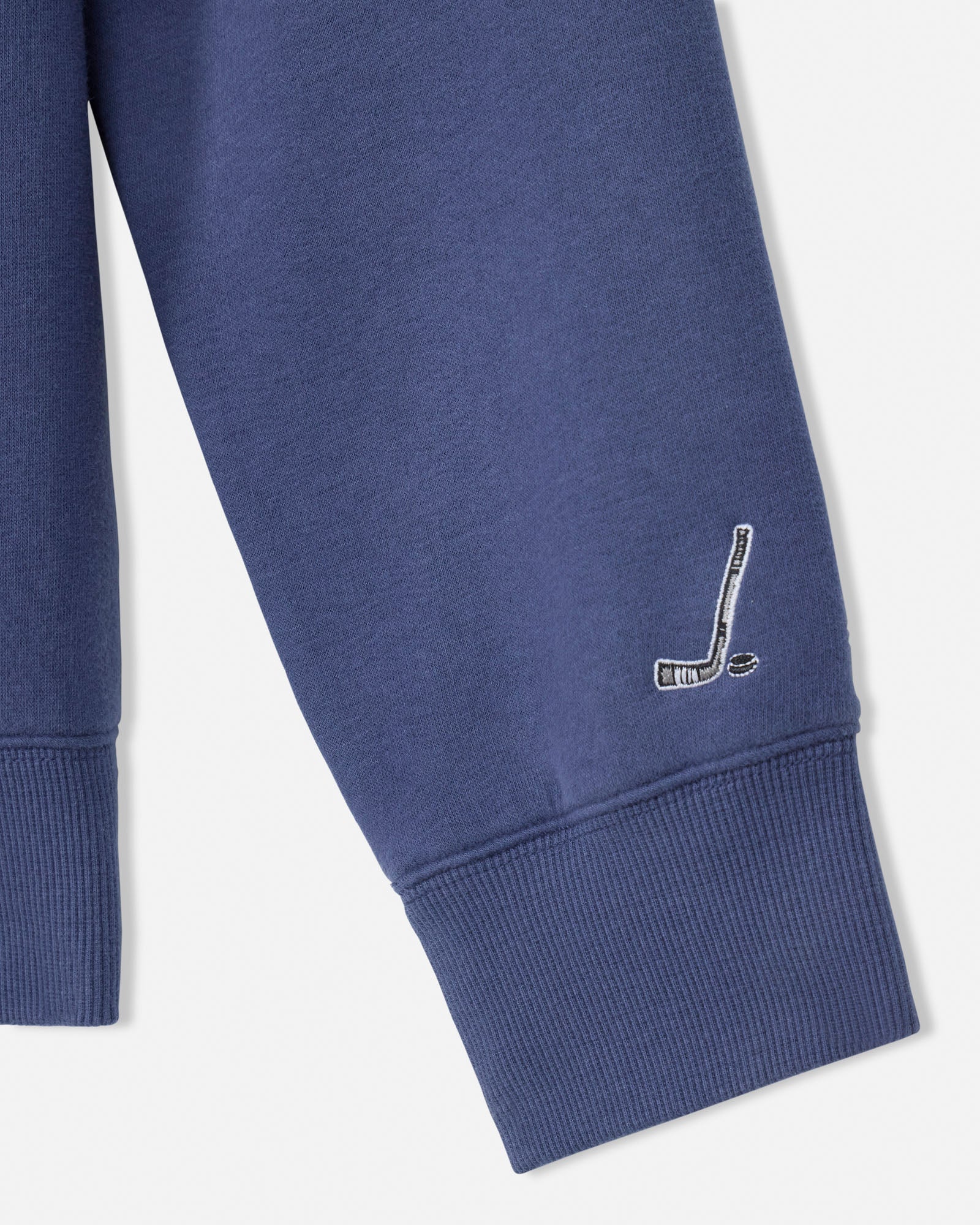 Blue sweatshirt with a small logo on the sleeve against a white background