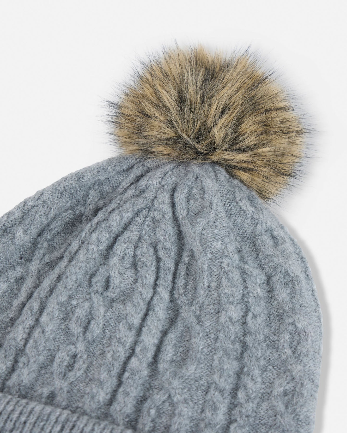 Gray knit beanie with a brown fur pom-pom on a white background