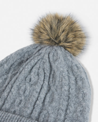 Gray knit beanie with a brown fur pom-pom on a white background