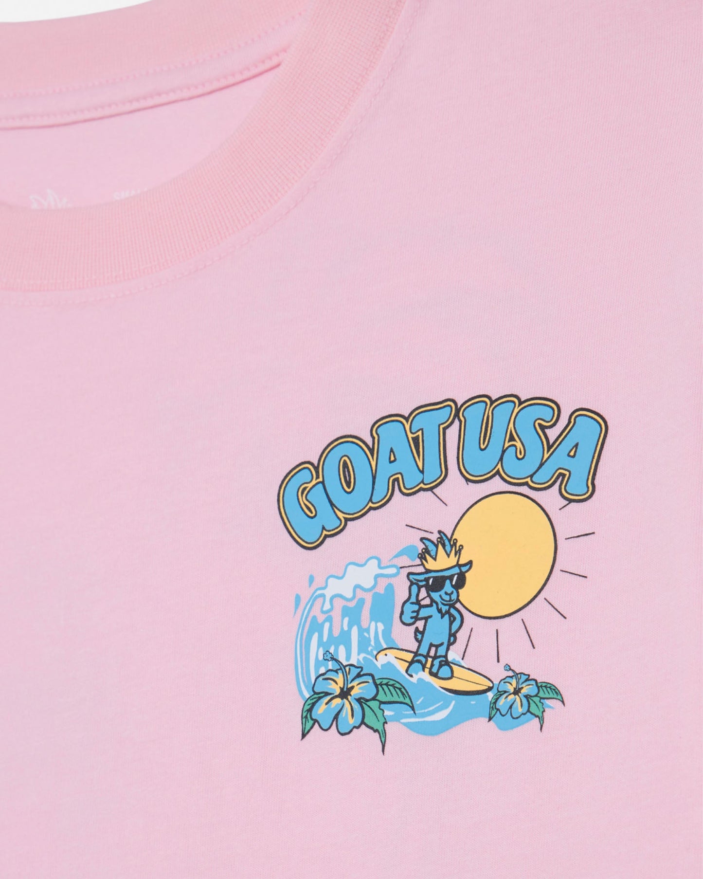 Pink t-shirt with 'GOAT USA' graphic design featuring a character on a wave.