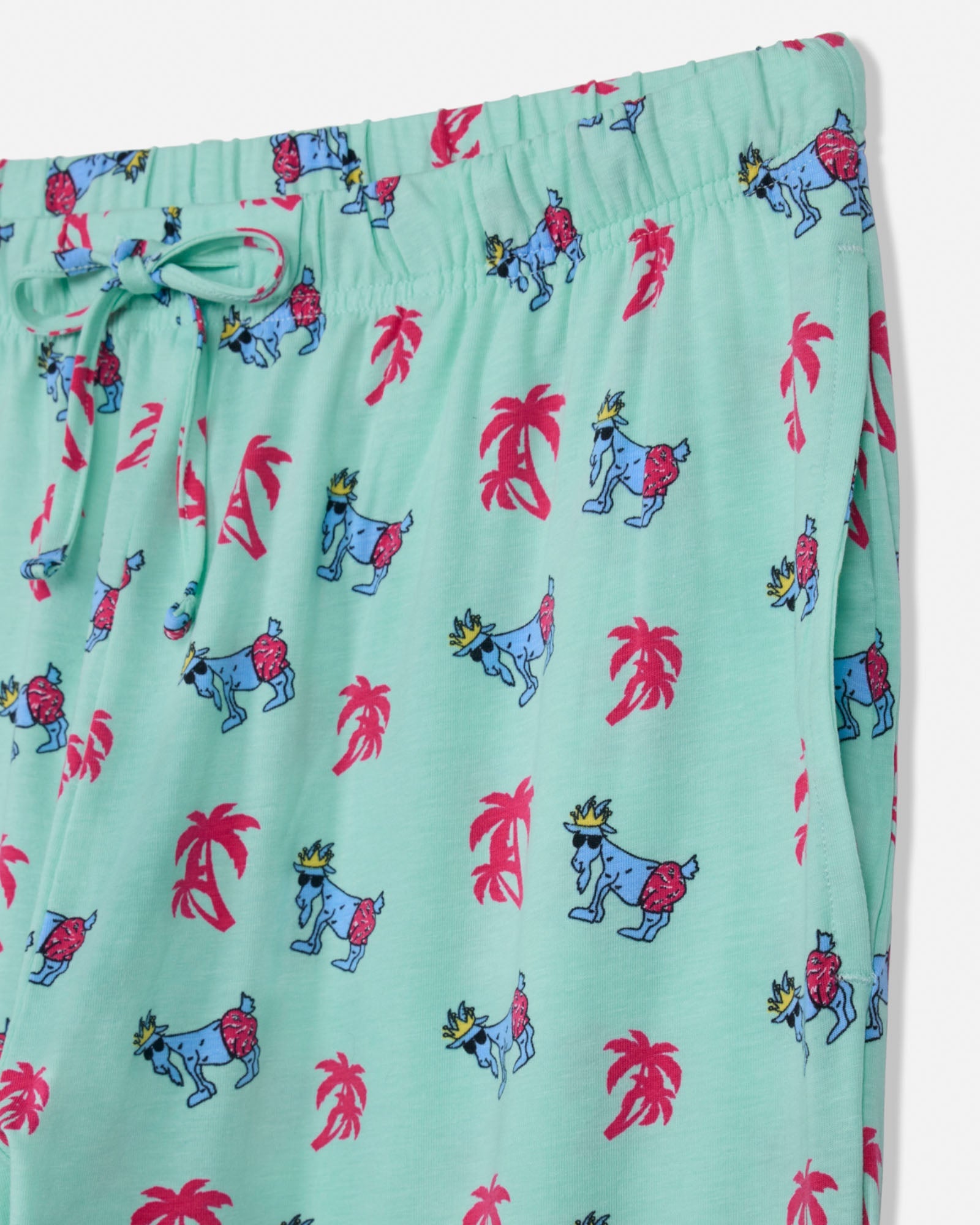 Mint pajama pants with colorful animal and palm tree pattern on a white background