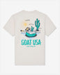 Beige t-shirt with a graphic of a goat in a pool and cactus, with 'GOAT USA' text on a white background.