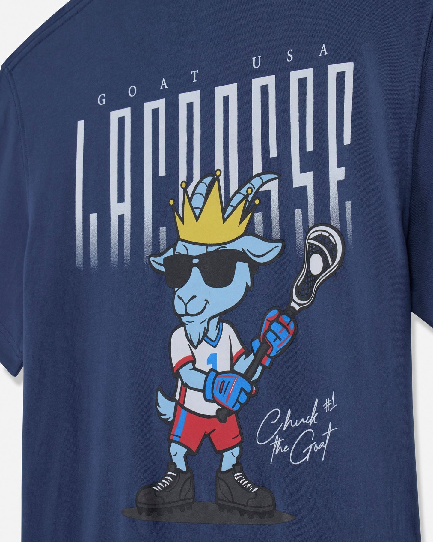 Navy blue t-shirt with a cartoon goat holding a lacrosse stick and wearing sunglasses, with 'GOAT USA Lacrosse' text above.