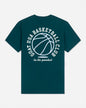 A dark teal green short-sleeve t-shirt with a white graphic print on the back featuring a basketball and the text 'GOAT USA BASKETBALL CLUB' and 'be the greatest'.