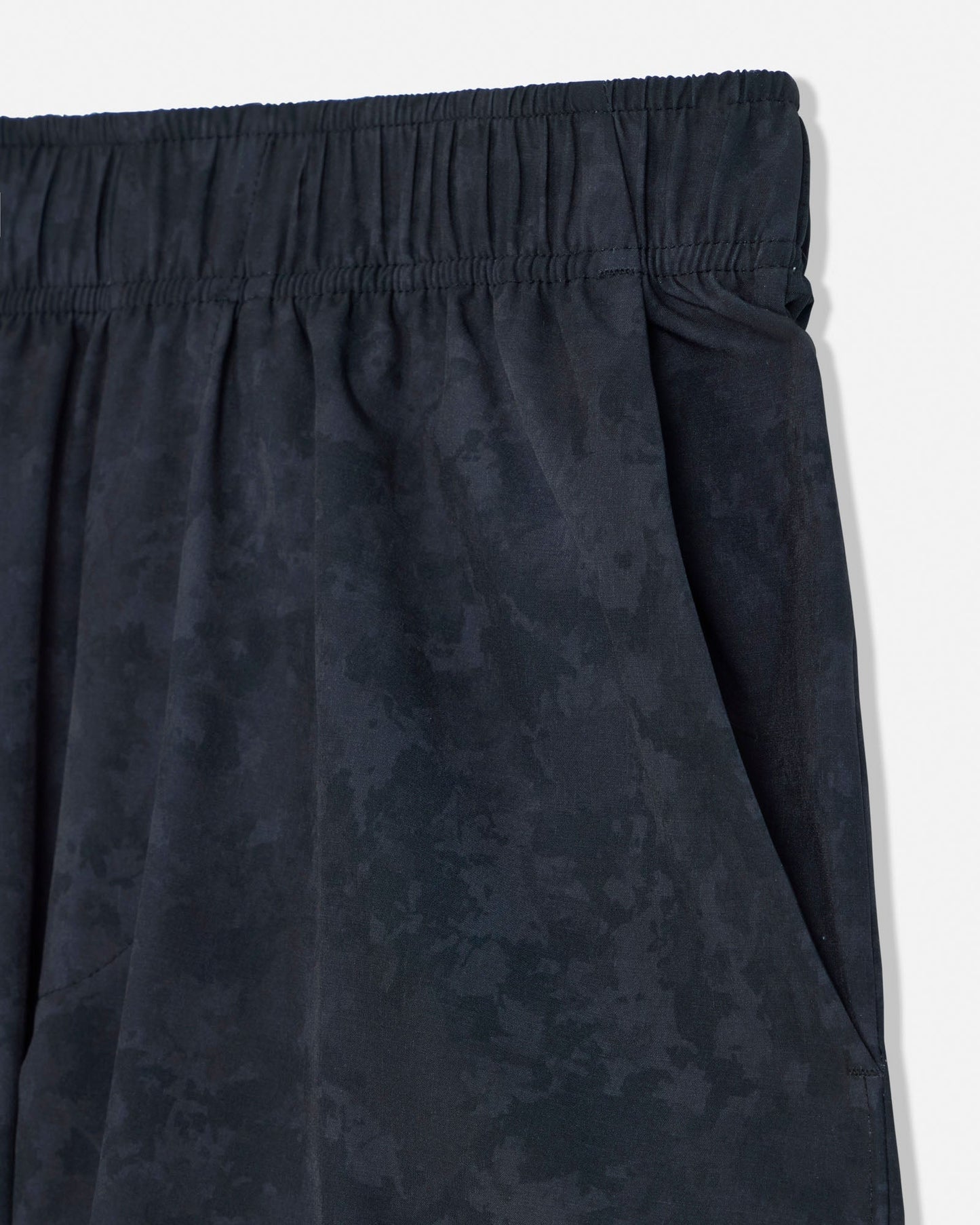 Black shorts with an elastic waistband on a light gray background#color_black-camo