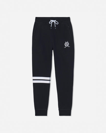 Black sweatpants with a white drawstring, a small white crest logo on the left thigh, and two horizontal white stripes near the lower left leg, shown against a light gray background.