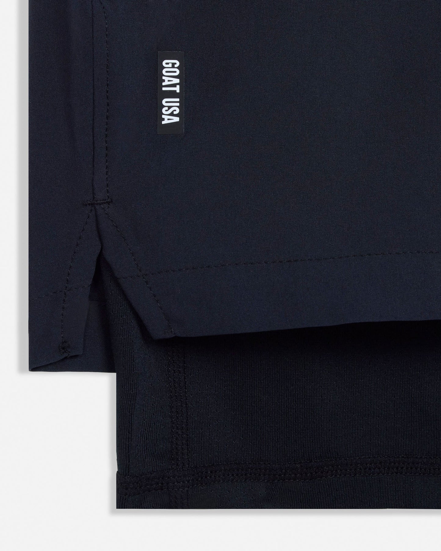 Close-up of a black garment with 'GOAT USA' logo on a white background#color_black