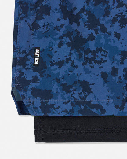 Blue camouflage shorts with a visible brand logo on a white background#color_navy-camo