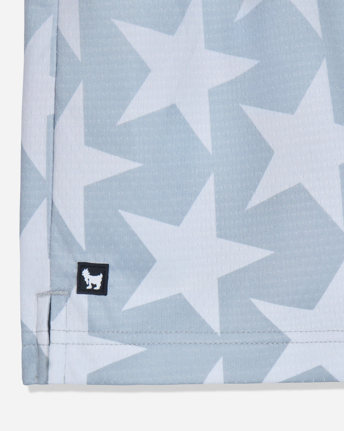 Close-up of rubber patch on gray mesh shorts with a star pattern#color_gray