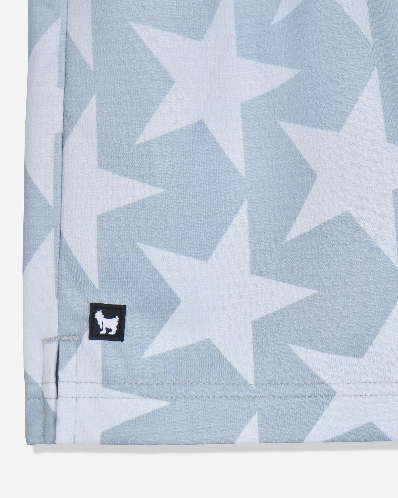 Close-up of rubber patch on gray mesh shorts with a star pattern#color_gray