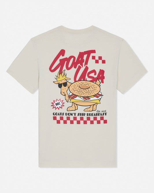 Beige t-shirt with a cartoon goat wearing sunglasses and a crown, labeled 'GOAT USA', on a white background.
