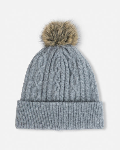 Gray knit beanie with a fur pom-pom on a light gray background