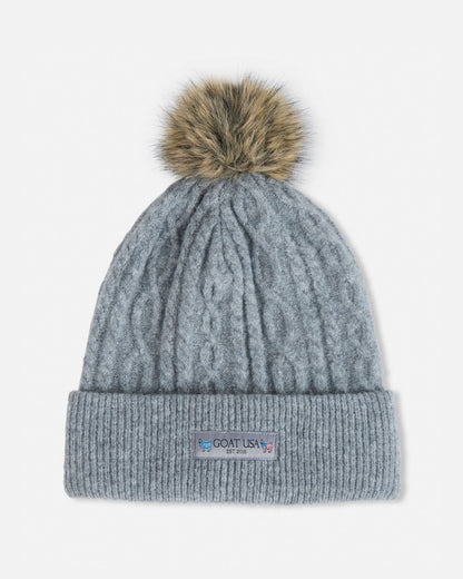 Gray knit beanie with a fur pom-pom on a light gray background