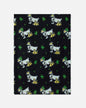 A rectangular black fleece blanket featuring a repeating pattern of white Scottish terriers wearing gold collars and green hats, with green dollar signs.