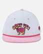 White and pink cap with 'GOAT USA' design on a light gray background