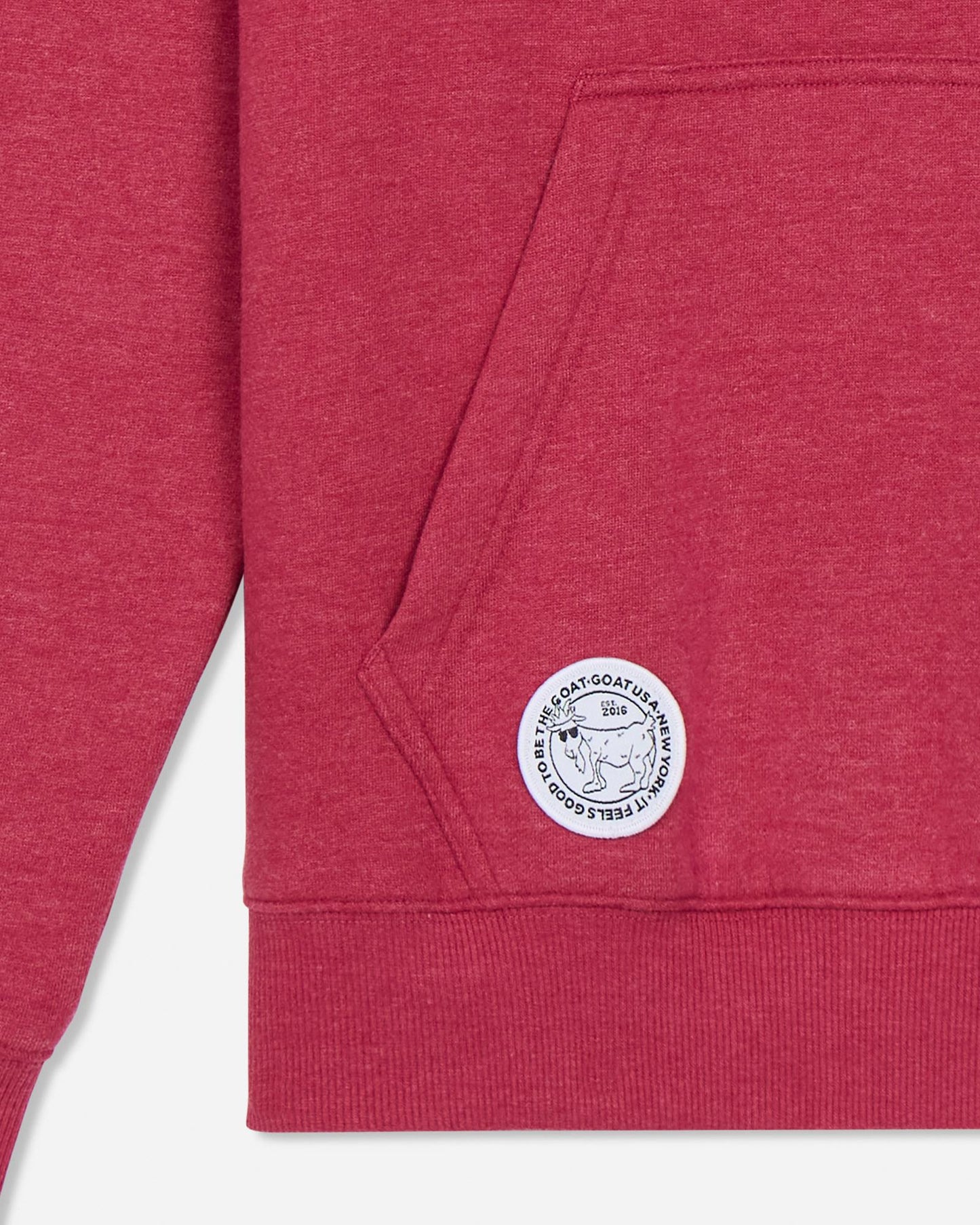 Close-up of a red sweatshirt with a logo on the pocket against a light gray background#color_cardinal