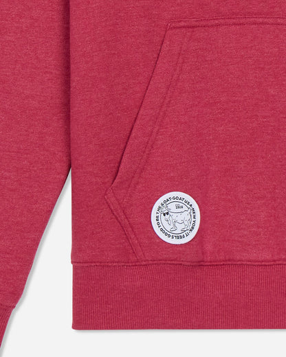 Close-up of a red sweatshirt with a logo on the pocket against a light gray background#color_cardinal