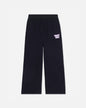 Black wide-leg sweatpants with an elastic waistband and a small white 'GOAT USA' text graphic on the left thigh, shown against a light gray background.#color_black