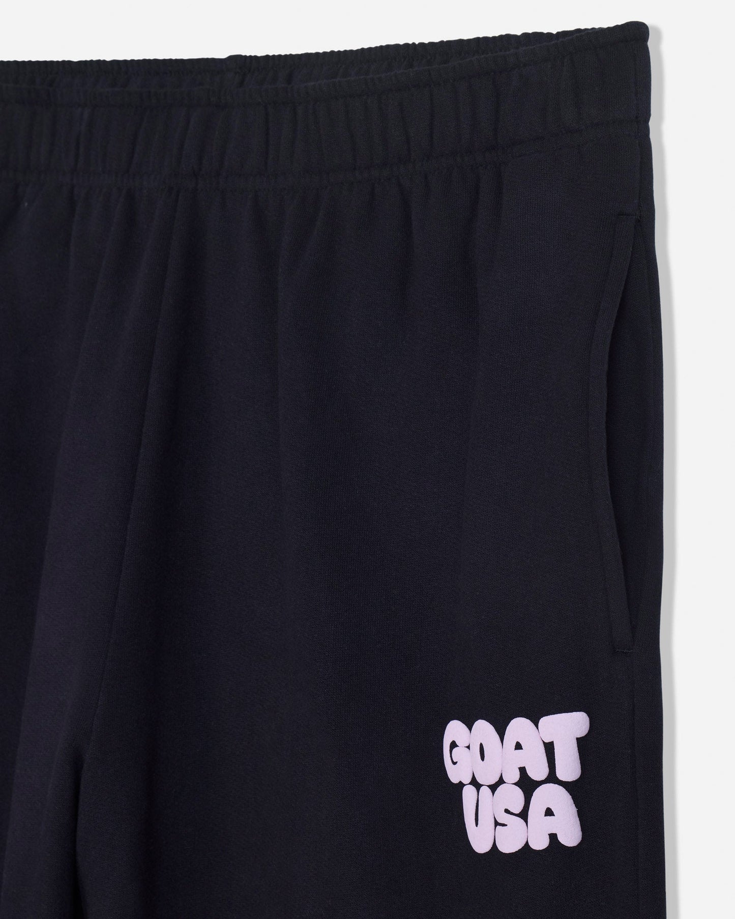 Close-up of pocket on black sweatpants and 'GOAT USA' text#color_black