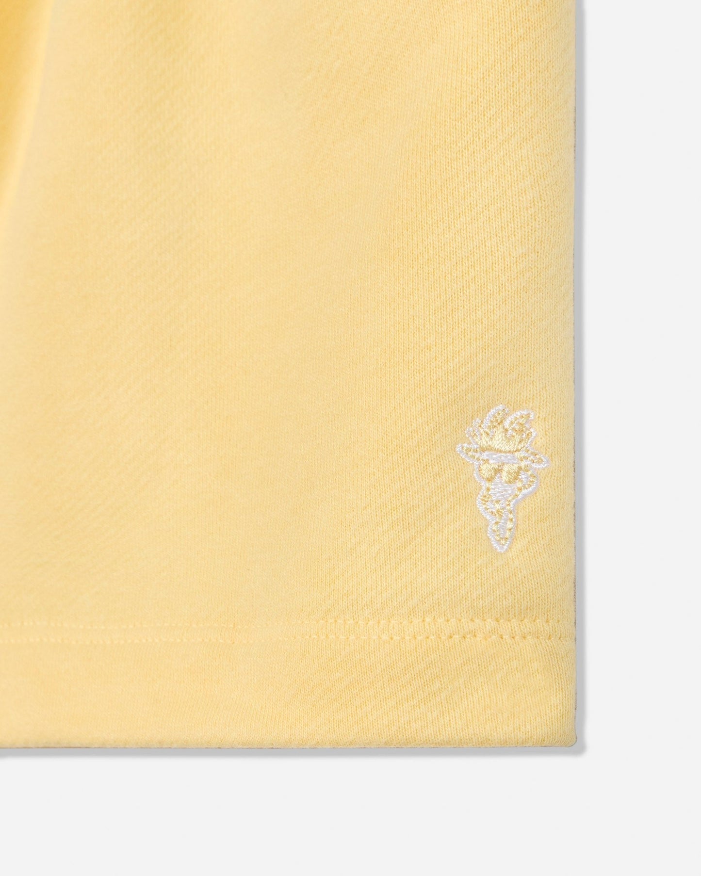 Close-up of corn milk sweat shorts goat head embroidery#color_corn-milk