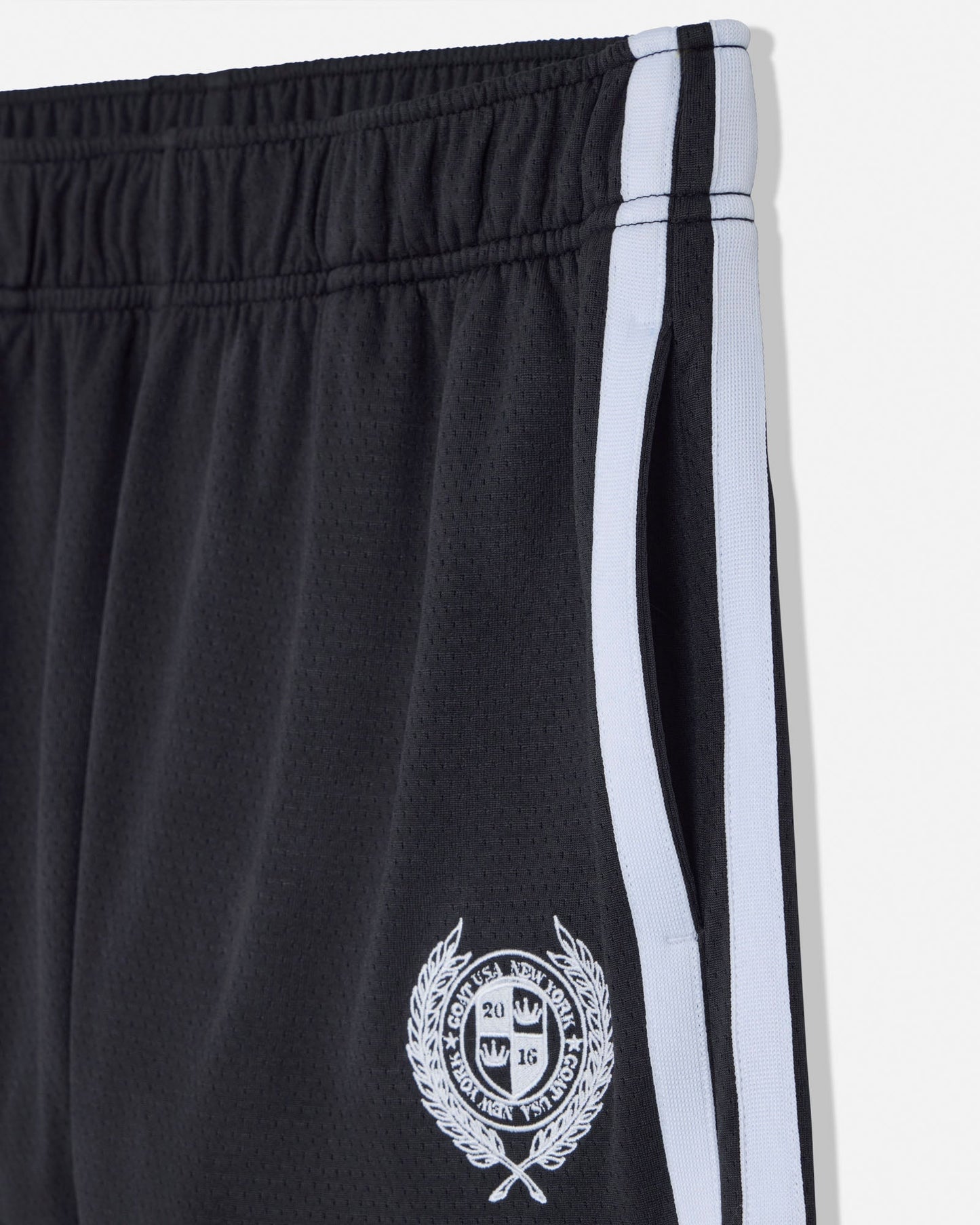 Black shorts with a white stripe and emblem on a white background#color_black