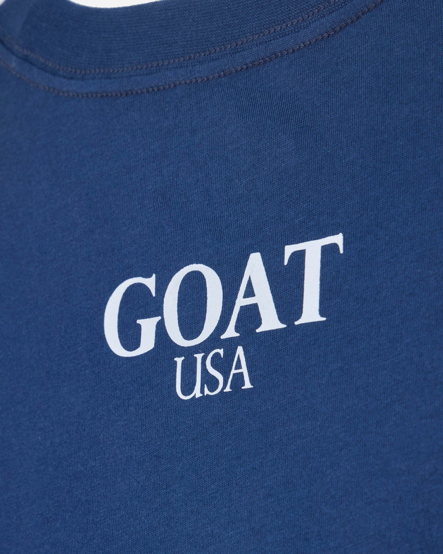 Close up of back of blue oversized crop top with 'GOAT USA' text#color_moonlite-ocean