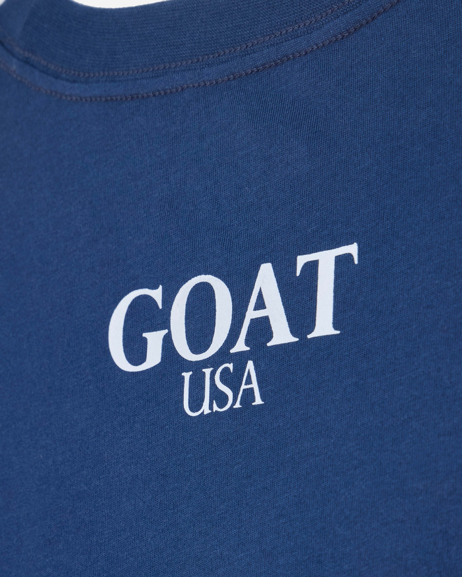 Close up of back of blue oversized crop top with 'GOAT USA' text#color_moonlite-ocean