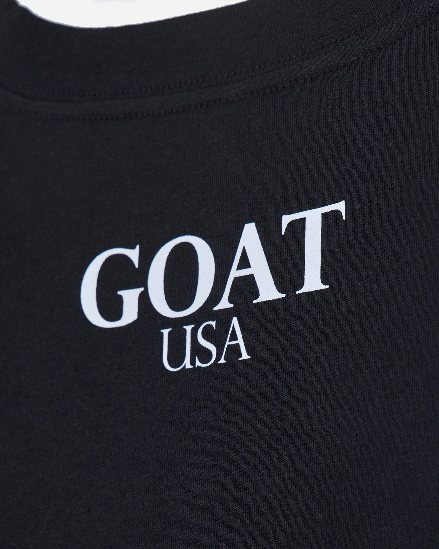 Close up of back of black oversized crop top with 'GOAT USA' text#color_black