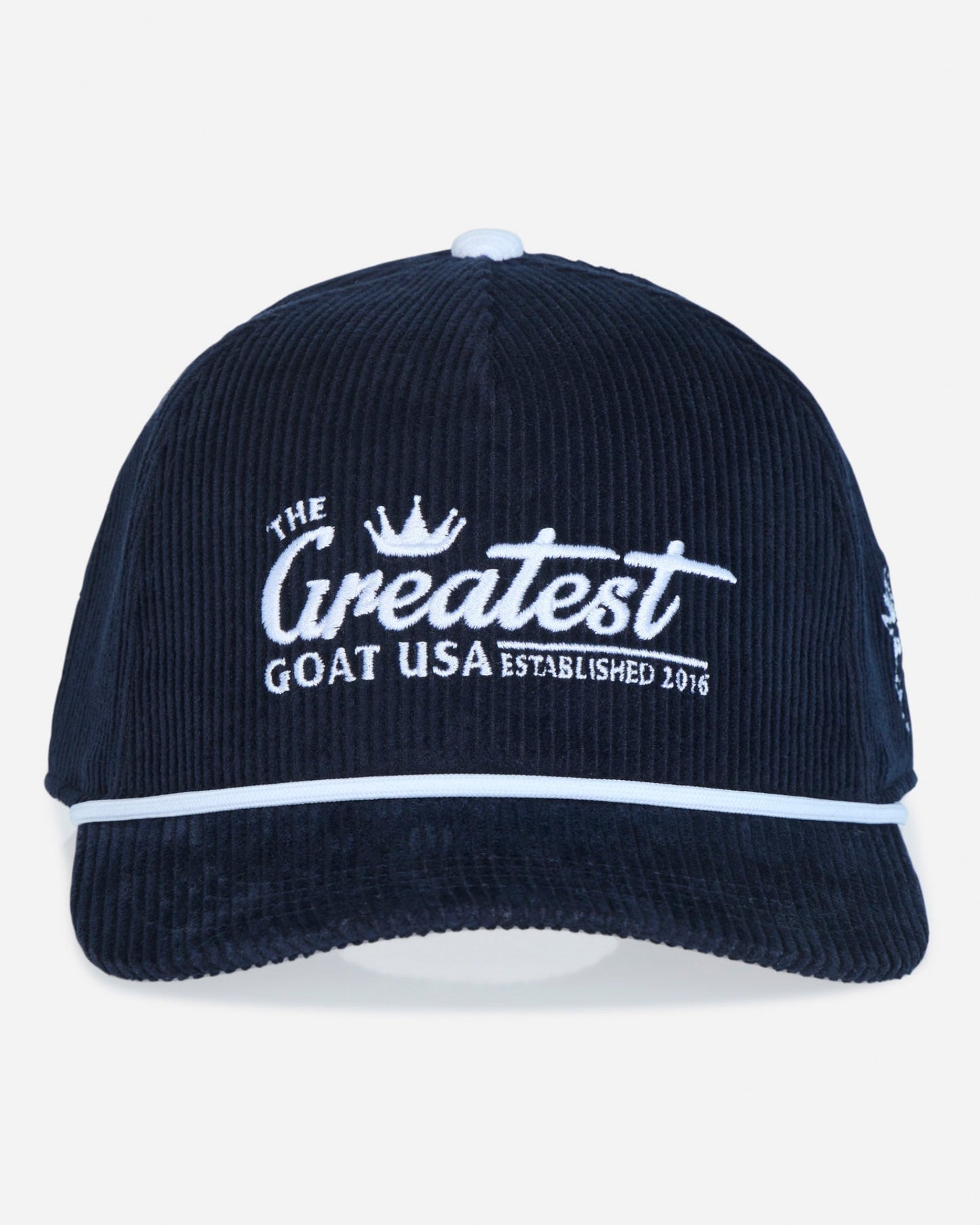 A dark navy blue corduroy baseball cap with white embroidered text reading 'The Greatest Goat USA Established 2016' on the front, featuring a white piping accent along the brim.