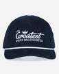 A dark navy blue corduroy baseball cap with white embroidered text reading 'The Greatest Goat USA Established 2016' on the front, featuring a white piping accent along the brim.