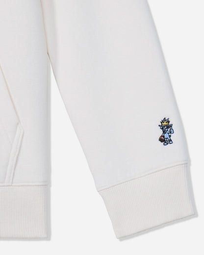 Close-up of a white ribbed cuff on a sweatshirt or hoodie, featuring a small embroidered blue and yellow character on the lower cuff.