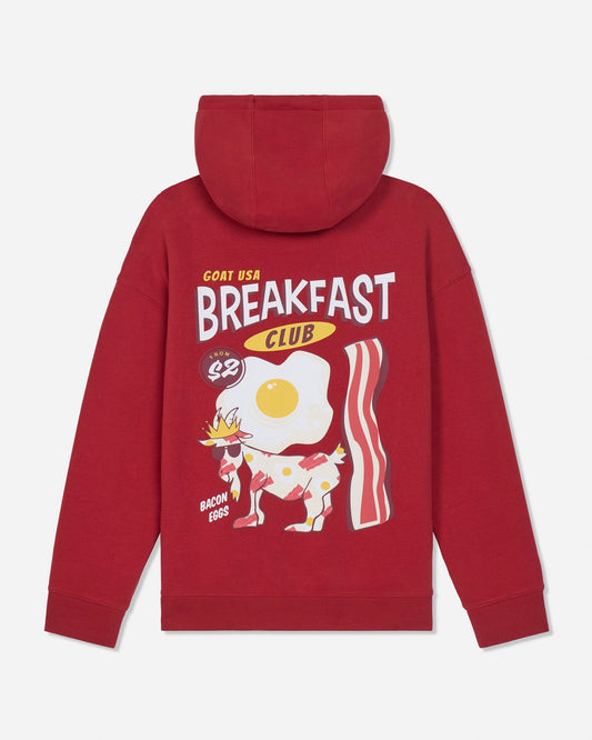 A red pullover hoodie shown from the back, featuring a large graphic print of a breakfast-themed goat wearing sunglasses, with text reading 'GOAT USA BREAKFAST CLUB' and 'BACON EGGS'.