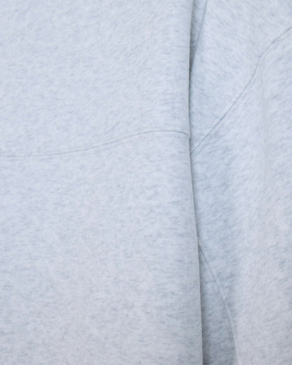 Close-up of a light heather gray fabric with soft folds and stitched seams.