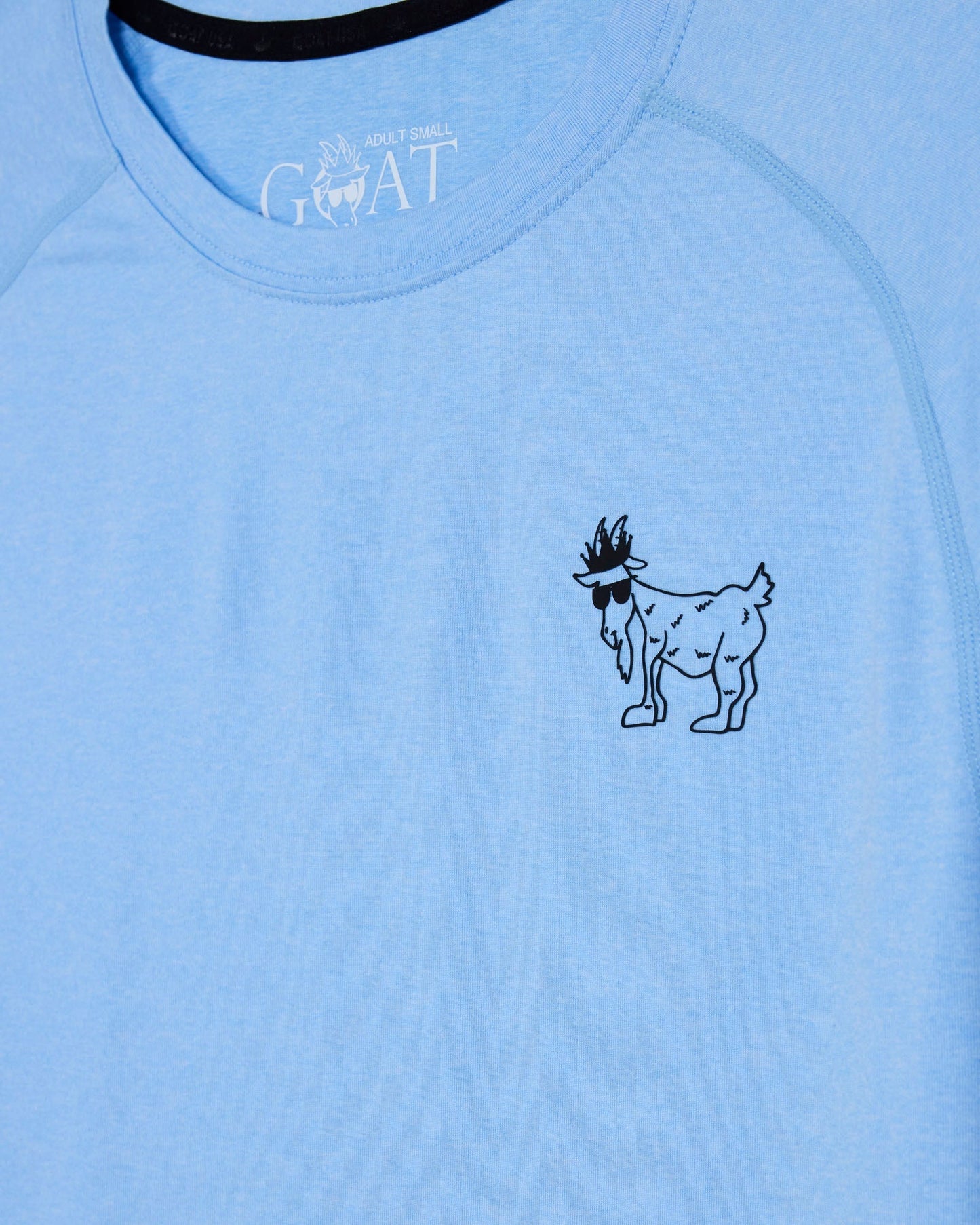 Light blue t-shirt with a black graphic of a goat and 'GOAT' text on a blue background#color_carolina-blue