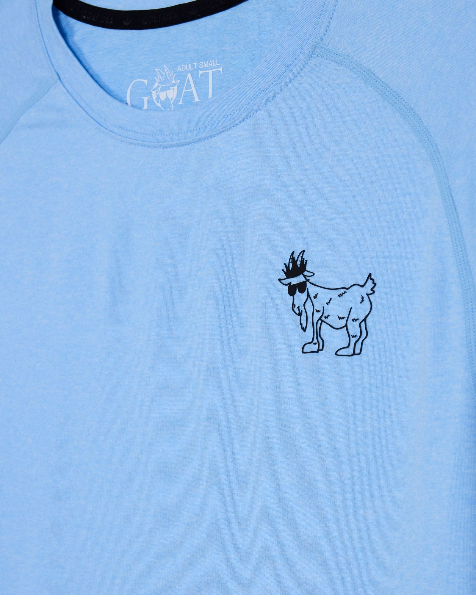 Light blue t-shirt with a black graphic of a goat and 'GOAT' text on a blue background#color_carolina-blue