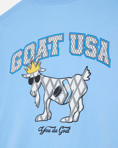 Light blue t-shirt with a graphic of a goat wearing a crown and 'GOAT USA' text.