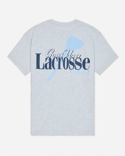 A light heather gray short-sleeve t-shirt with a graphic on the front reading 'Goat USA Lacrosse Club' in navy and light blue, featuring a lacrosse stick design.