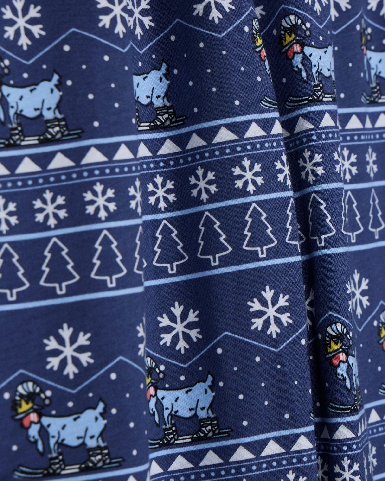 Navy blue fabric with white snowflakes, trees, and blue animals on skis pattern