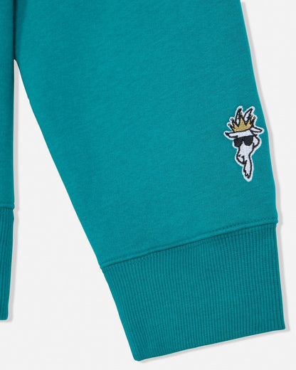 Teal sweatshirt with a decorative patch on a white background#color_teal-blue