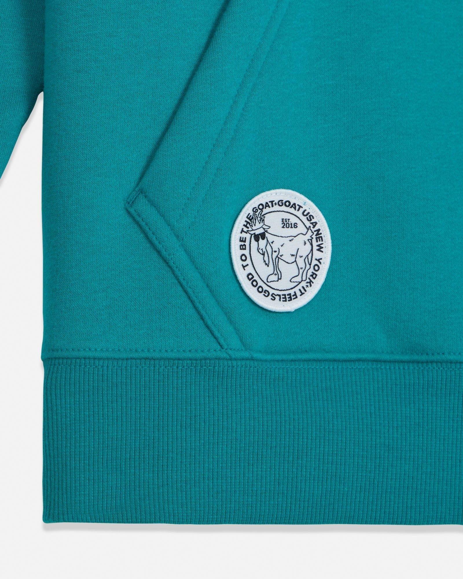 Teal sweatshirt with a logo patch on a white background#color_teal-blue