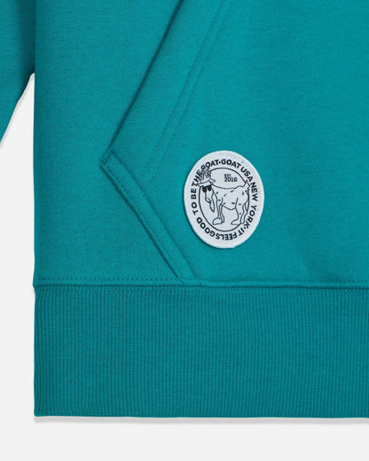 Teal sweatshirt with a logo patch on a white background#color_teal-blue