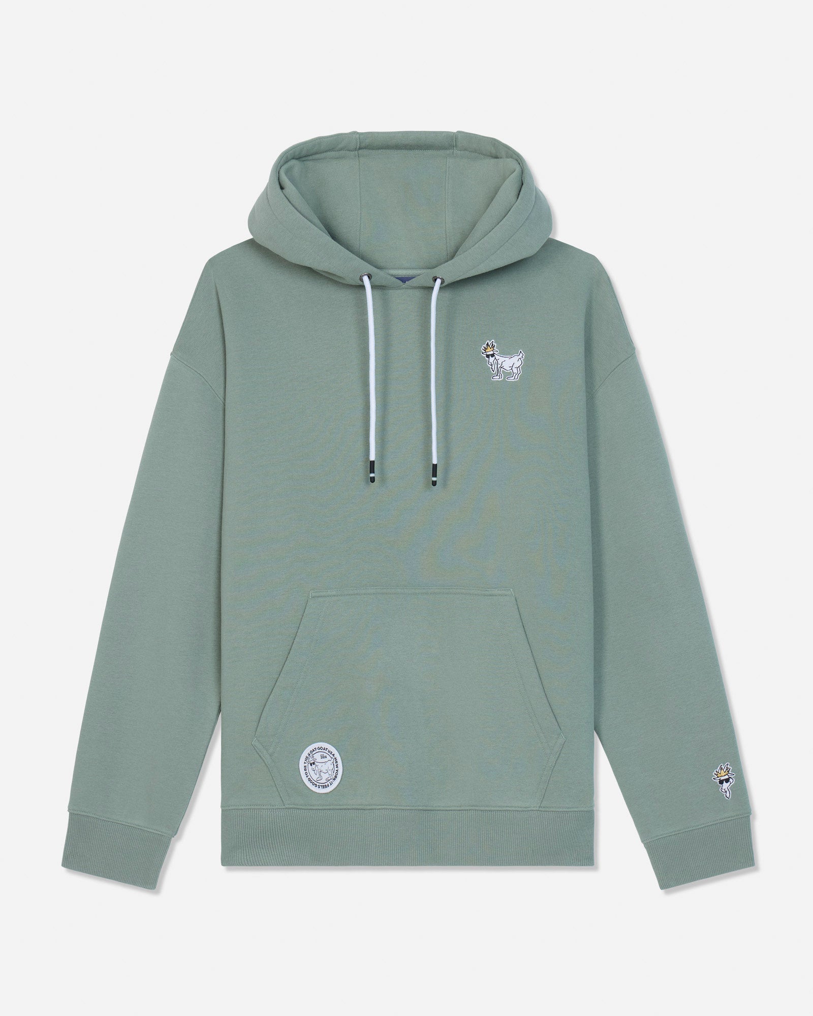 A sage green pullover hoodie with white drawstrings, featuring a small white goat graphic on the left chest and a circular patch on the lower left front pocket, displayed against a light gray background.#color_steeped-sage