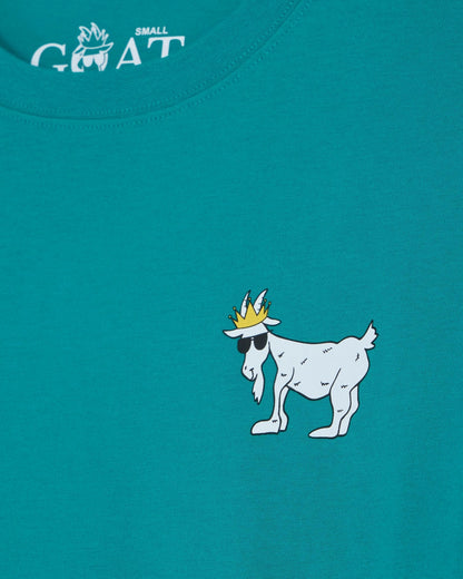 Teal t-shirt with a white cartoon goat wearing a crown and sunglasses on a blue background.#color_teal-blue