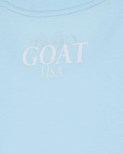 Light blue shirt with 'GOAT USA' text on a light blue background#color_delicate-blue