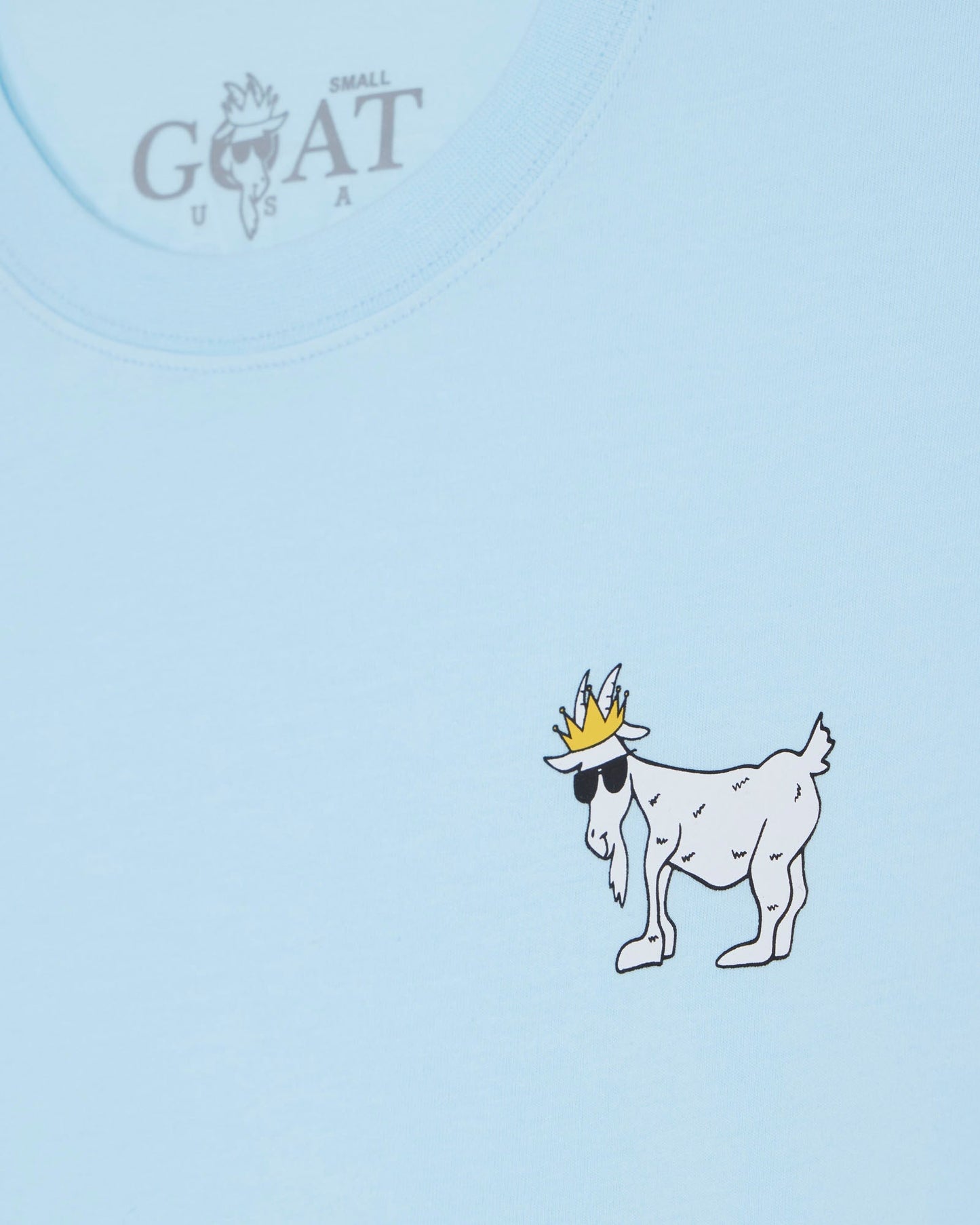 Light blue t-shirt with a cartoon goat wearing a crown on a light blue background.#color_delicate-blue